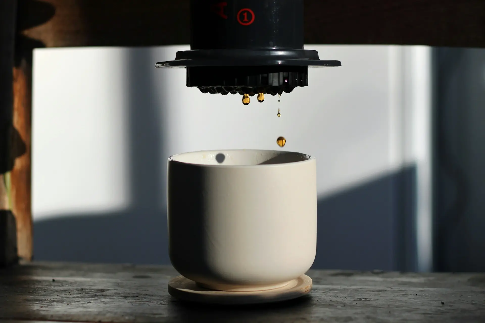 a coffee cup being poured into a white cup