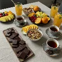 table with coffee, tea, chocolate, fruits, nuts, and mocktails.webp